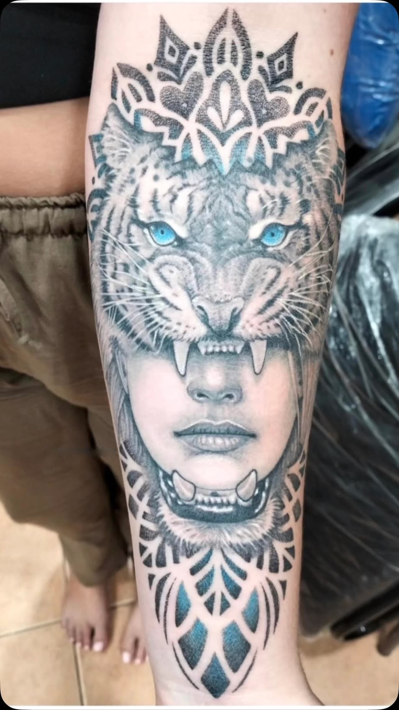 Woman wearing a tiger head with mandala, realistic tattoo